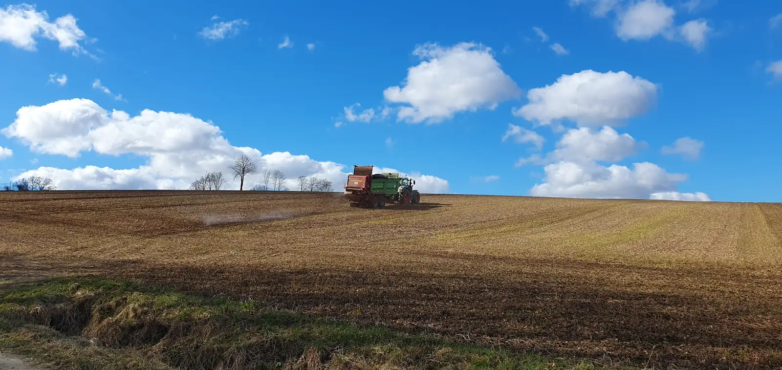 Traktor auf dem Feld vor blauem Himmel